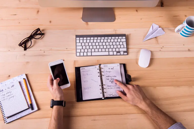 Schreibtisch mit Planer, Tastatur und Notizen bei der Projektplanung